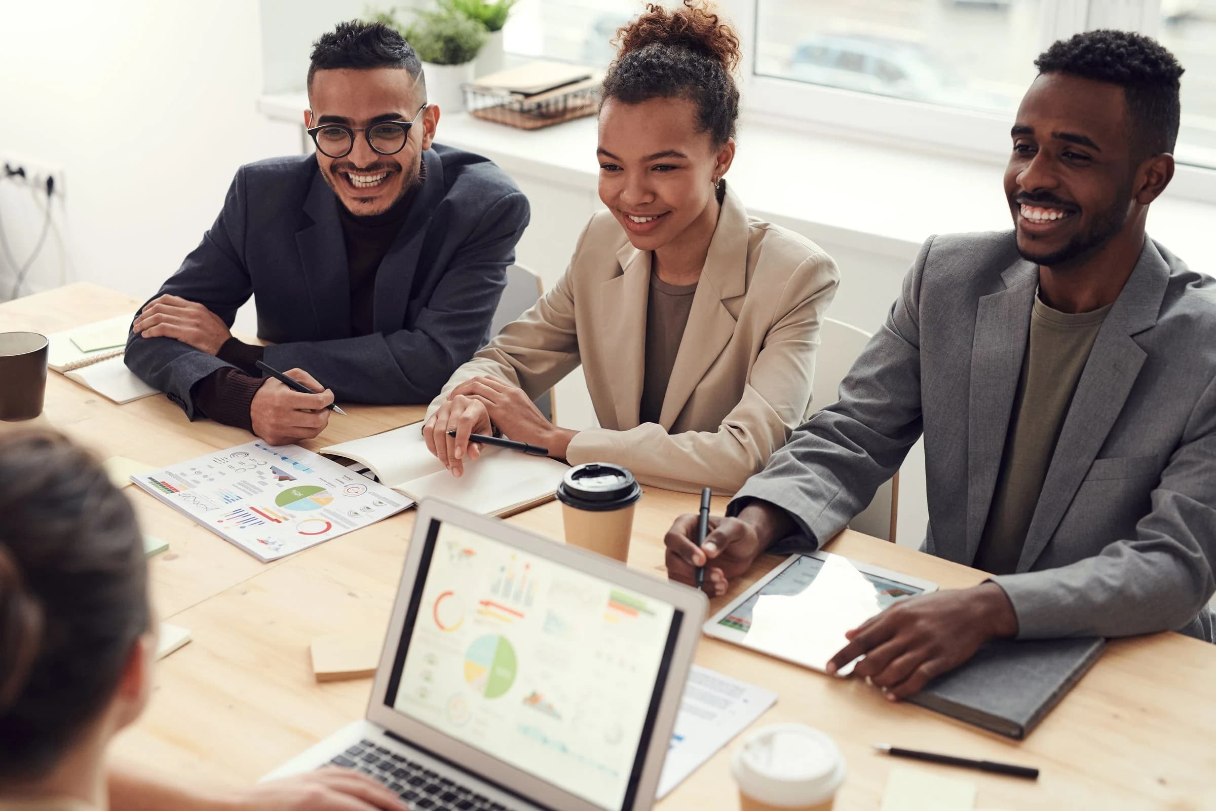 Business colleagues reviewing a shared plan around a table