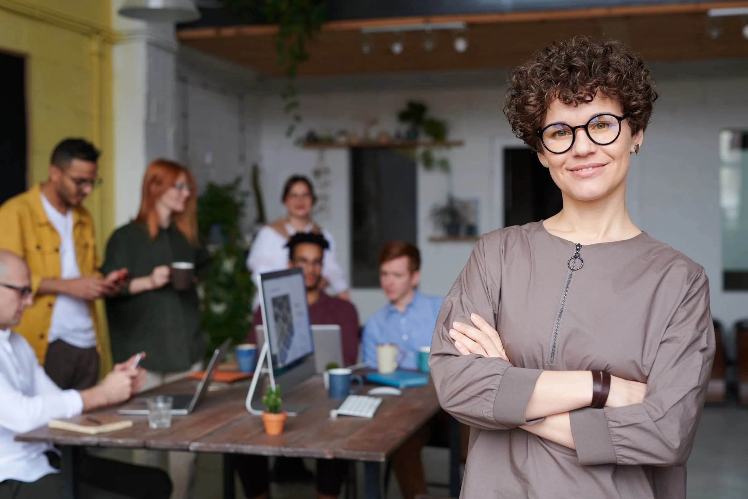 Business leader with her team at work behind her
