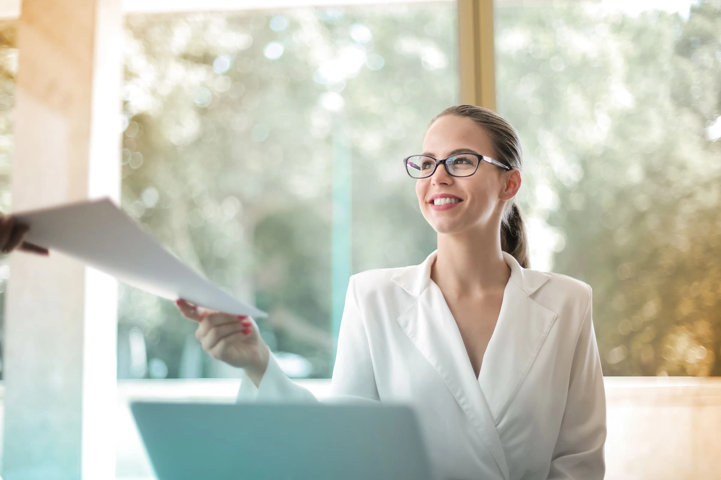 Professional managing a conversation and documents at her desk