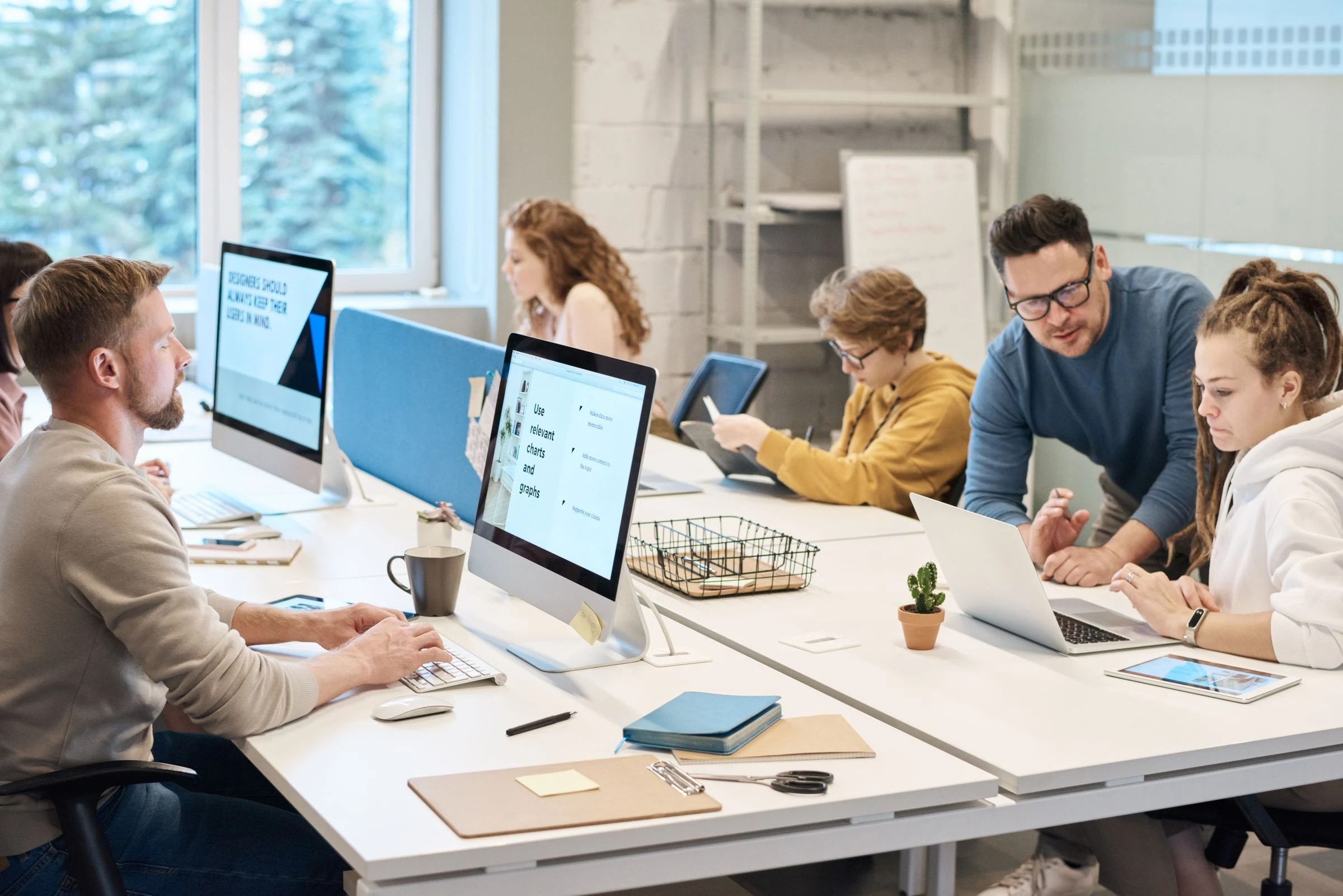 Colleagues coordinating work across their desks